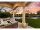 Covered patio with comfortable seating, leading to a well-manicured lawn and stone fireplace at 9290 E Thompson Peak Pkwy # 142, Scottsdale, AZ 85255