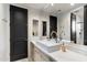 Modern bathroom featuring a stylish vanity with marble countertop and a sleek black door at 9290 E Thompson Peak Pkwy # 142, Scottsdale, AZ 85255