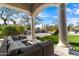 Covered patio with an outdoor seating area, fire pit, and stone fireplace with manicured landscaping at 9290 E Thompson Peak Pkwy # 142, Scottsdale, AZ 85255