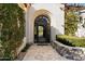 Elegant arched entryway featuring iron detailing and surrounded by lush, well-maintained landscaping at 9290 E Thompson Peak Pkwy # 142, Scottsdale, AZ 85255