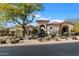 Charming exterior showcasing desert landscaping, tile roof, and an arched entry gate at 9290 E Thompson Peak Pkwy # 142, Scottsdale, AZ 85255