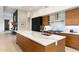 Kitchen featuring a large island with a white marble countertop and wood cabinetry at 9290 E Thompson Peak Pkwy # 142, Scottsdale, AZ 85255