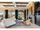 Airy living room with stone fireplace, wood beam ceiling, and large windows showcasing a garden view at 9290 E Thompson Peak Pkwy # 142, Scottsdale, AZ 85255