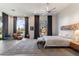 Bright bedroom with a large rug, neutral tones, and large windows with a desert landscape at 9290 E Thompson Peak Pkwy # 142, Scottsdale, AZ 85255