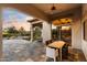 Covered outdoor dining area featuring stylish seating, and a stone patio with views of the landscaped yard at 9290 E Thompson Peak Pkwy # 142, Scottsdale, AZ 85255