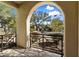 Inviting patio view showcasing desert landscaping through an arched entryway with black iron railings at 9290 E Thompson Peak Pkwy # 142, Scottsdale, AZ 85255