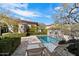 Inviting pool area with lounge chairs, mature landscaping, and a tranquil stone water feature at 9290 E Thompson Peak Pkwy # 142, Scottsdale, AZ 85255