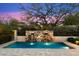 Enjoy the backyard pool with stone waterfall features, mature landscaping, and tranquil privacy at 9290 E Thompson Peak Pkwy # 142, Scottsdale, AZ 85255