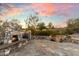 Picturesque stone fireplace with a waterfall feature surrounded by lush landscaping at sunset at 9290 E Thompson Peak Pkwy # 142, Scottsdale, AZ 85255