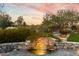 Beautiful waterfall feature surrounded by lush landscaping, with mountain views at sunset at 9290 E Thompson Peak Pkwy # 142, Scottsdale, AZ 85255