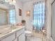 Well-lit bathroom with patterned shower curtain, white fixtures and decorative touches at 9313 W Arrowhead Dr, Sun City, AZ 85351