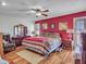 Warm bedroom with a queen bed, red accent wall, and a full dresser at 9313 W Arrowhead Dr, Sun City, AZ 85351