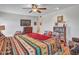 Bright bedroom featuring a queen bed, television, ceiling fan, and a bookcase at 9313 W Arrowhead Dr, Sun City, AZ 85351