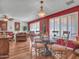 Dining area with glass table, chandelier, red accent wall, and direct access to the living room at 9313 W Arrowhead Dr, Sun City, AZ 85351