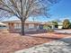 Charming brick home featuring a well-manicured yard with desert landscaping and mature tree at 9313 W Arrowhead Dr, Sun City, AZ 85351