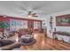 Bright living room with hardwood floors, comfortable sofas, and a view into the dining area at 9313 W Arrowhead Dr, Sun City, AZ 85351