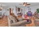 Spacious living area with wood-look floors and comfortable furniture, connecting dining room and fireplace at 9313 W Arrowhead Dr, Sun City, AZ 85351