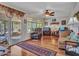 Inviting living room featuring hardwood floors, ceiling fan, and sunroom access perfect for relaxing and entertaining at 9313 W Arrowhead Dr, Sun City, AZ 85351