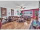 Inviting living room with hardwood floors, two sofas, fan, and red accent wall at 9313 W Arrowhead Dr, Sun City, AZ 85351