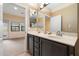 Bright bathroom with double sinks and a large mirror, leading to a bedroom with a balcony at 10829 N 11Th Pl, Phoenix, AZ 85020