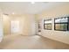 Spacious living room showcasing neutral walls, large windows, and a door to the balcony at 10829 N 11Th Pl, Phoenix, AZ 85020
