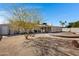 Expansive backyard with desert landscaping, a round wooden deck, and a covered patio area perfect for outdoor entertaining at 1530 E Alameda Dr, Tempe, AZ 85282