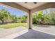 A covered patio overlooks a manicured lawn and mature landscaping in the backyard at 1737 E Azalea Dr, Gilbert, AZ 85298