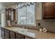 Kitchen view of the sink, granite counter, tile backsplash and dark wood cabinets at 1737 E Azalea Dr, Gilbert, AZ 85298