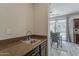 Wet bar with granite countertop, stainless steel sink, and gray-tone wood flooring at 1737 E Azalea Dr, Gilbert, AZ 85298