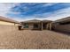 Backyard featuring neutral walls and gravel landscaping with desert accents and bright blue sky at 18644 N Desert Willow Dr, Maricopa, AZ 85138