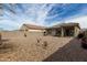 Expansive gravel backyard with a covered patio, block wall and ample space for customization and relaxation at 18644 N Desert Willow Dr, Maricopa, AZ 85138