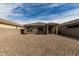 View of backyard featuring low maintenance landscaping, covered patio, and block wall fencing providing privacy at 18644 N Desert Willow Dr, Maricopa, AZ 85138