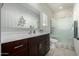 Bright bathroom featuring a dark wood vanity, large mirror, and glass-enclosed shower at 18644 N Desert Willow Dr, Maricopa, AZ 85138