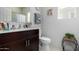 Well-lit bathroom with dark wood vanity, white countertop, and a toilet at 18644 N Desert Willow Dr, Maricopa, AZ 85138