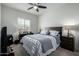 Well-lit bedroom featuring a ceiling fan, a window, and matching dark wood furniture at 18644 N Desert Willow Dr, Maricopa, AZ 85138