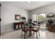 Cozy dining area with a glass table, four chairs, a cabinet, and natural light from a sliding glass door at 18644 N Desert Willow Dr, Maricopa, AZ 85138