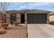 Single story home with desert landscaping, tile roof, neutral color stucco, and a large two car garage at 18644 N Desert Willow Dr, Maricopa, AZ 85138