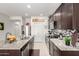 Modern kitchen featuring dark cabinets, stainless appliances, granite countertops, and tile backsplash at 18644 N Desert Willow Dr, Maricopa, AZ 85138