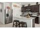 Modern kitchen featuring granite countertops, stainless steel appliances, and dark wood cabinets at 18644 N Desert Willow Dr, Maricopa, AZ 85138