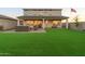 Large backyard with artificial turf, covered patio, and mountain views in the distance at 19201 W Missouri Ave, Litchfield Park, AZ 85340