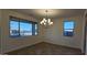 Dining area features a modern chandelier, wood-look tile flooring, and large windows for natural light at 19201 W Missouri Ave, Litchfield Park, AZ 85340