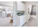 Bright hallway with white cabinets, leading to an office space and bathroom at 19201 W Missouri Ave, Litchfield Park, AZ 85340