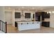 Modern kitchen boasts a large island, stainless steel appliances, dark cabinetry, and tile backsplash at 19201 W Missouri Ave, Litchfield Park, AZ 85340