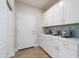 Laundry room features ample counter space, stylish blue tile, and lots of storage space at 19201 W Missouri Ave, Litchfield Park, AZ 85340