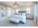 Bright main bedroom with a tray ceiling, elegant chandelier, and large window, creating a serene retreat at 19201 W Missouri Ave, Litchfield Park, AZ 85340