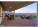 Expansive covered patio featuring stylish wicker furniture and views of the landscaped backyard at 19201 W Missouri Ave, Litchfield Park, AZ 85340
