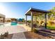 Backyard oasis featuring a pool, spa, pergola and well-manicured landscaping at 19912 E Natalie Way, Queen Creek, AZ 85142
