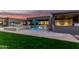 Resort style backyard features a covered kitchen, a pristine pool, and luscious green grass for outdoor living at 19912 E Natalie Way, Queen Creek, AZ 85142