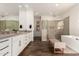 Modern bathroom features a double sink vanity, glass shower, bench seat, and a free standing tub at 19912 E Natalie Way, Queen Creek, AZ 85142