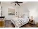 Well-lit bedroom featuring a bed with a patterned coverlet, side tables, and wood look tile flooring at 19912 E Natalie Way, Queen Creek, AZ 85142